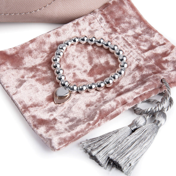 silver heart bracelet and pink velvet pouch